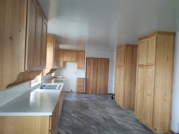 a kitchen with granite countertop wooden cabinets a sink and a refrigerator