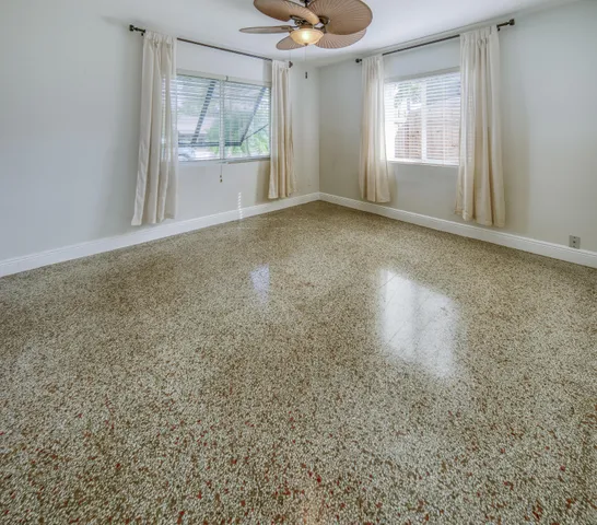 en empty room with window and wooden floor
