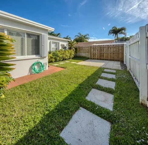 a view of a house with a small yard and flower plants