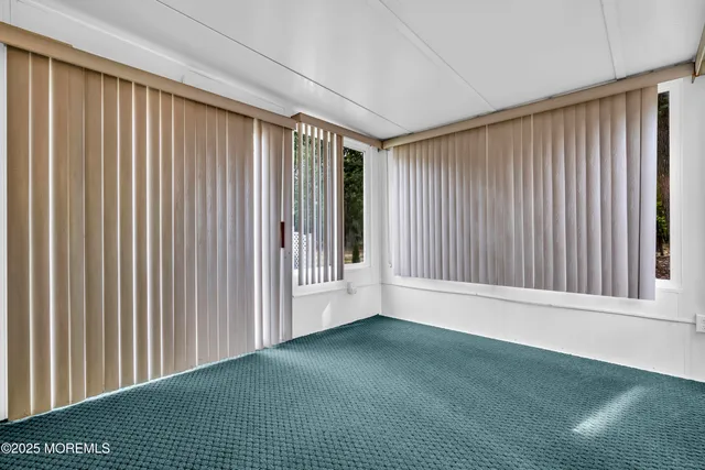 a view of a white house next to a yard and large trees