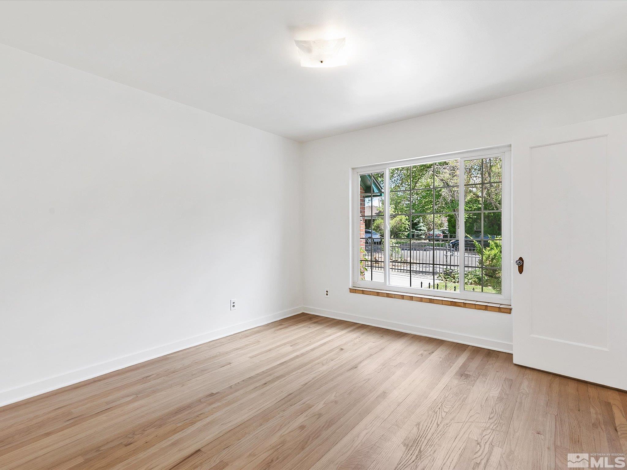 811 Washington Street Reno, NV 89503 - Photo 11 of 35 an empty room with wooden floor and windows