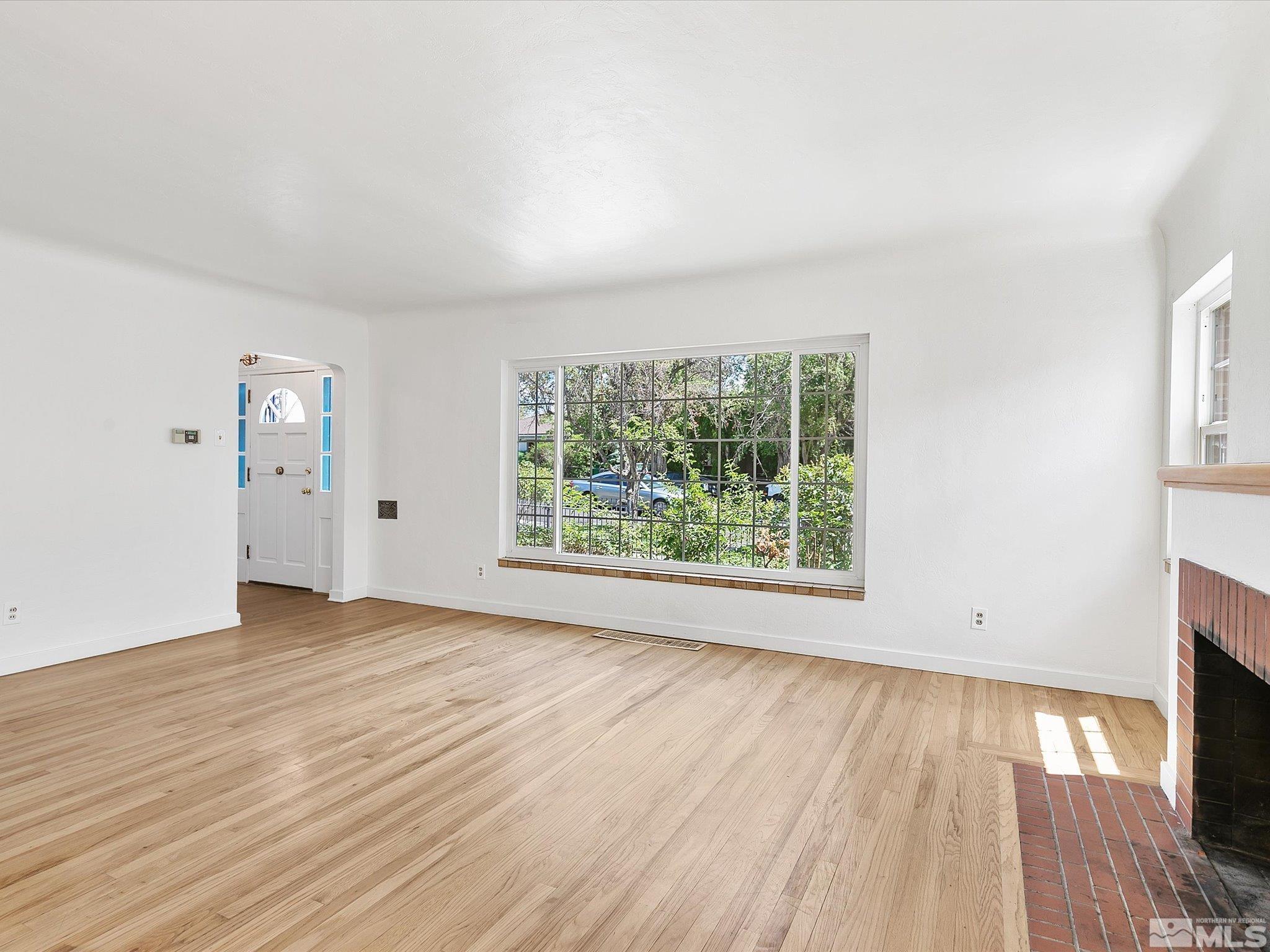 811 Washington Street Reno, NV 89503 - Photo 3 of 35 an empty room with wooden floor and windows