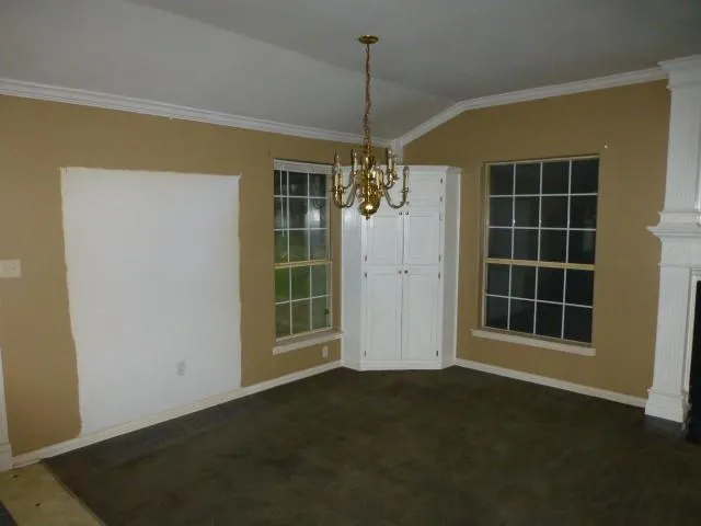 a view of empty room with windows and ceiling fan
