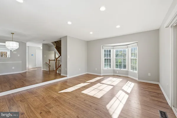 a view of kitchen with stainless steel appliances wooden floor and cabinets