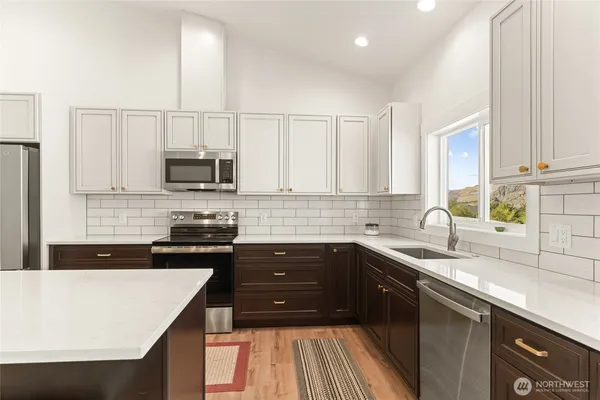 a kitchen with stainless steel appliances granite countertop a sink stove microwave and cabinets