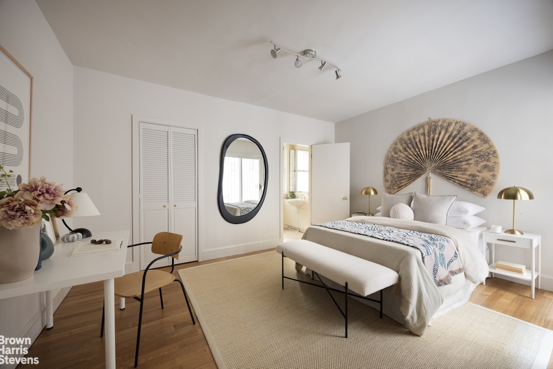 57 East 74th Street Manhattan, NY 10021 - Photo 27 of 60 a spacious bedroom with a bed and a chandelier