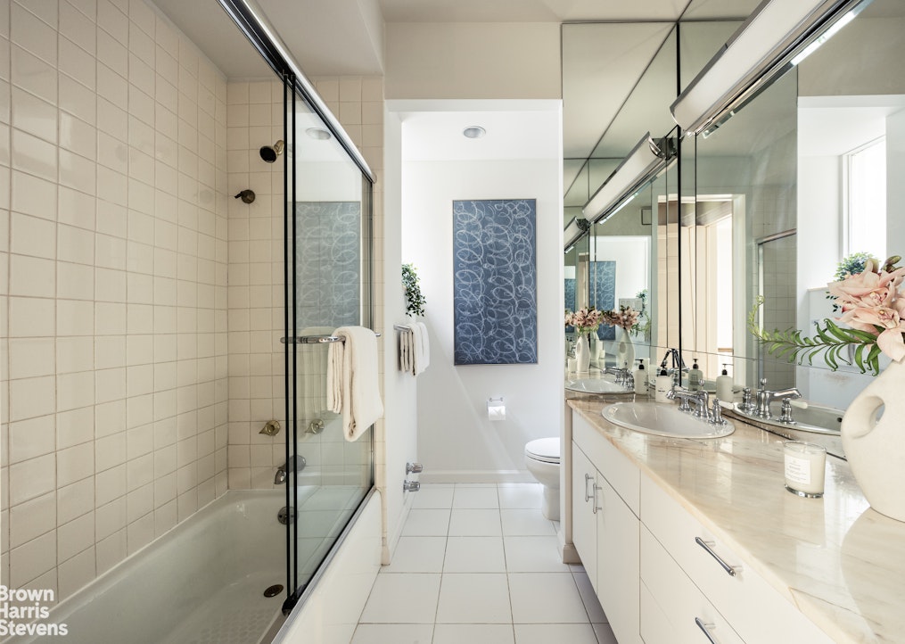 57 East 74th Street Manhattan, NY 10021 - Photo 31 of 60 a spacious bathroom with a tub shower and sink