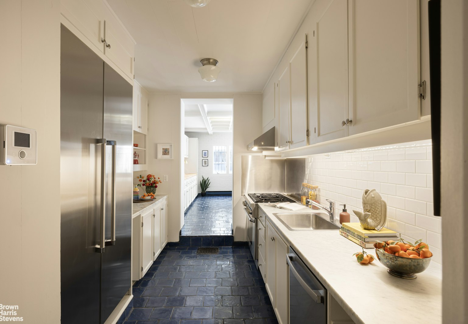 57 East 74th Street Manhattan, NY 10021 - Photo 44 of 60 a kitchen with stainless steel appliances a sink a stove and a refrigerator