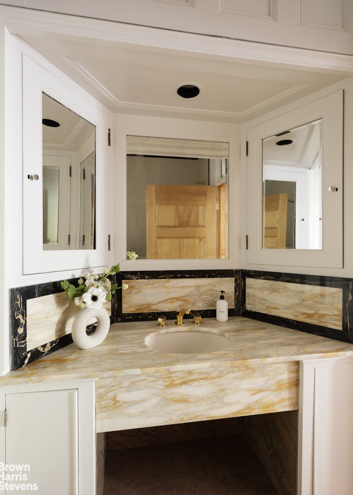 57 East 74th Street Manhattan, NY 10021 - Photo 55 of 60 a bathroom with a sink and a mirror