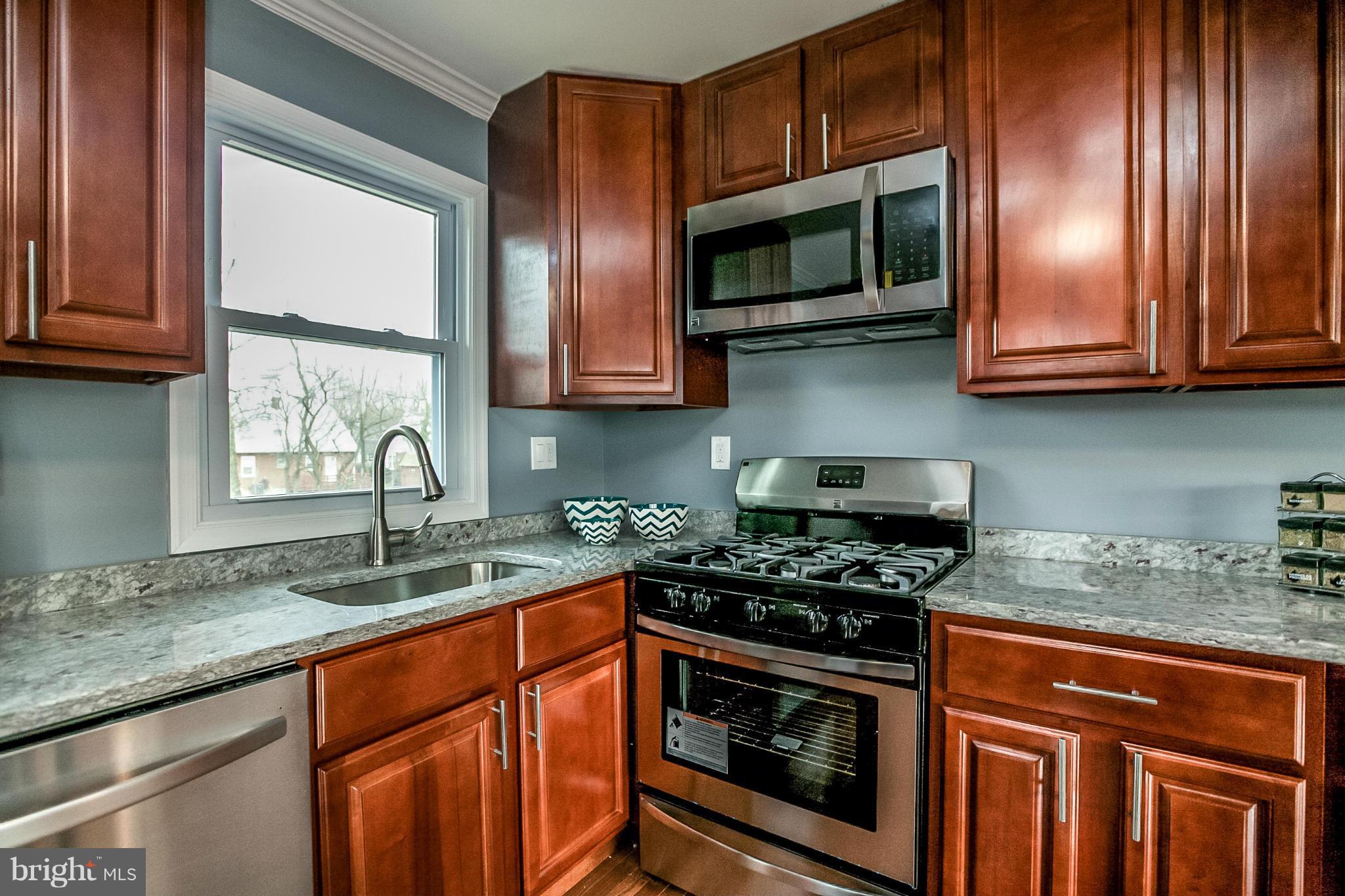 3534 Milford Mill Road Baltimore, MD 21244 - Photo 3 of 30 a kitchen with granite countertop stainless steel appliances a stove microwave and sink