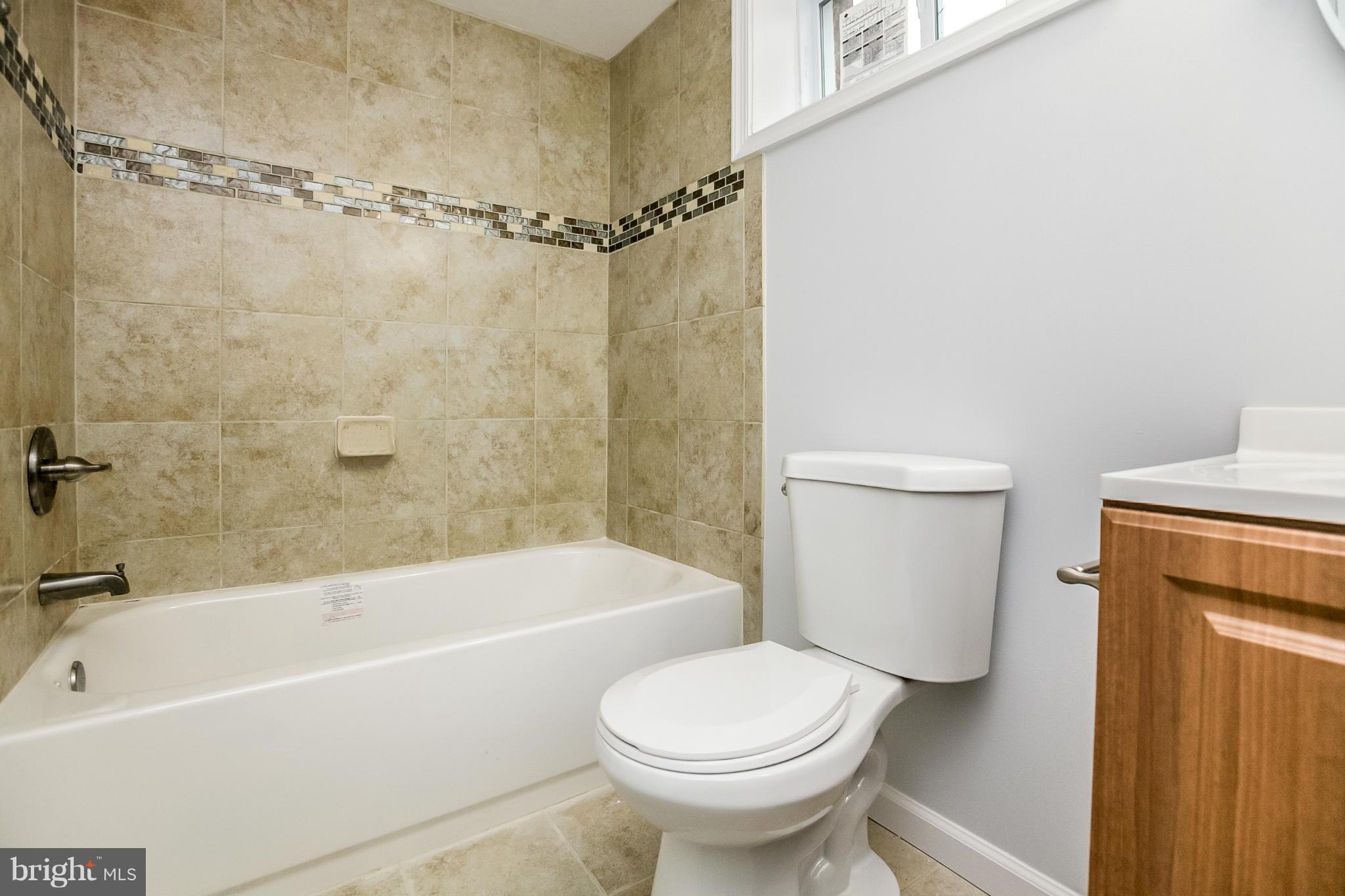 3534 Milford Mill Road Baltimore, MD 21244 - Photo 28 of 30 a bathroom with a shower a bathtub and a toilet