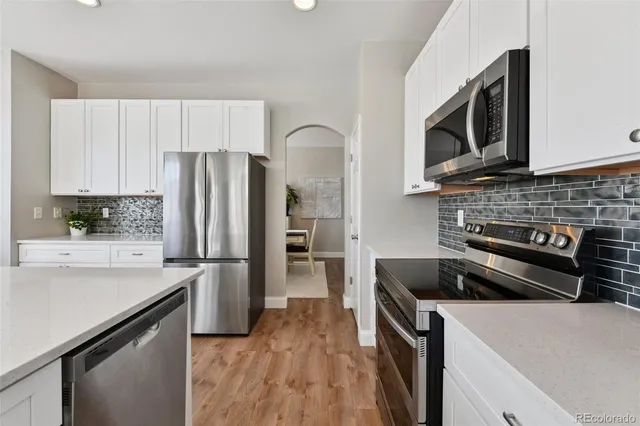 a kitchen with stainless steel appliances granite countertop a stove a sink and a microwave