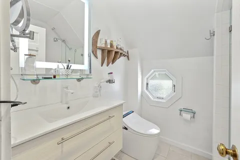 a bathroom with a granite countertop sink mirror vanity and toilet