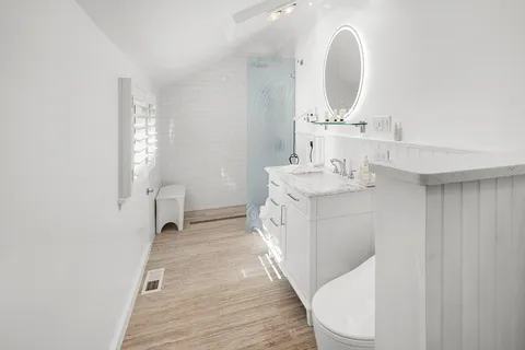 a bathroom with a sink a toilet and a mirror