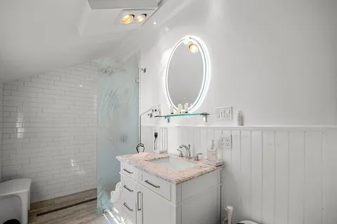 a bathroom with a granite countertop sink a mirror and a toilet