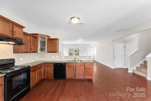 a large kitchen with stainless steel appliances granite countertop a sink and cabinets