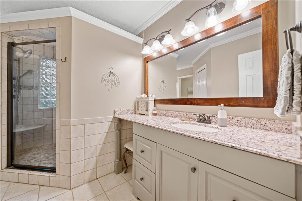 1008 River Estates Road Cleveland, GA 30528 - Photo 21 of 37 a bathroom with a granite countertop sink a mirror and shower