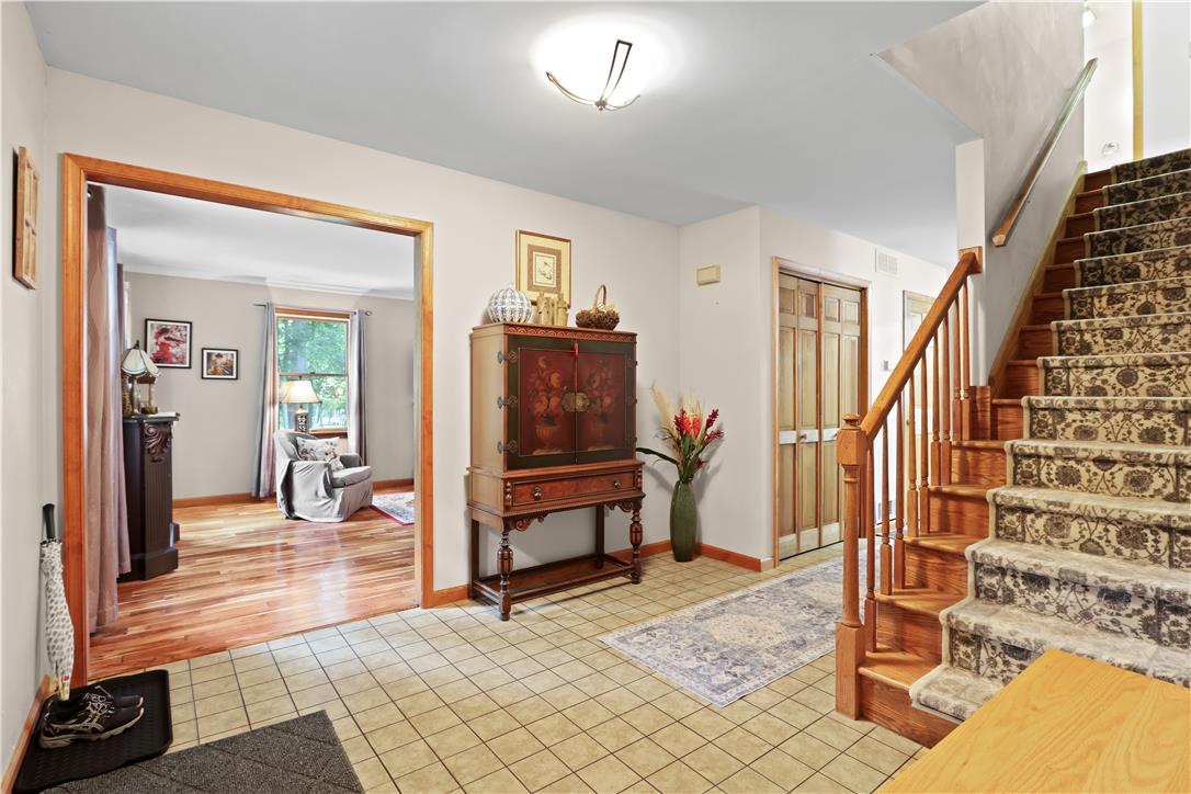 209 Remington Road East Stroudsburg, PA 18301 - Photo 22 of 41 A welcoming entry hall with tiled flooring seamlessly transitions into rich hardwood, leading to an elegant wooden staircase.