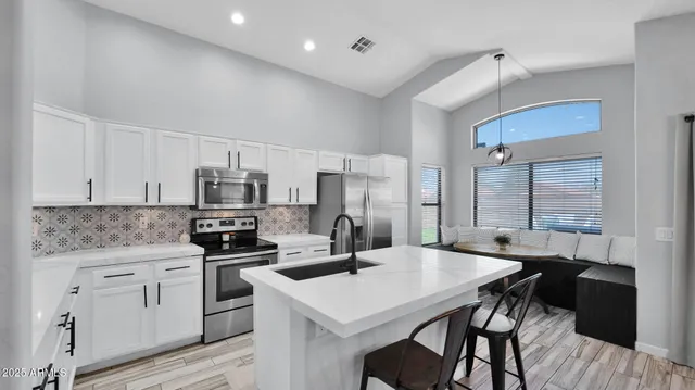 a kitchen with a table chairs sink and cabinets