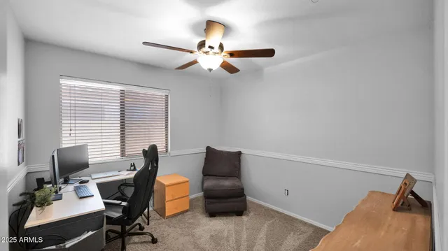 a view of a workspace with furniture and a window