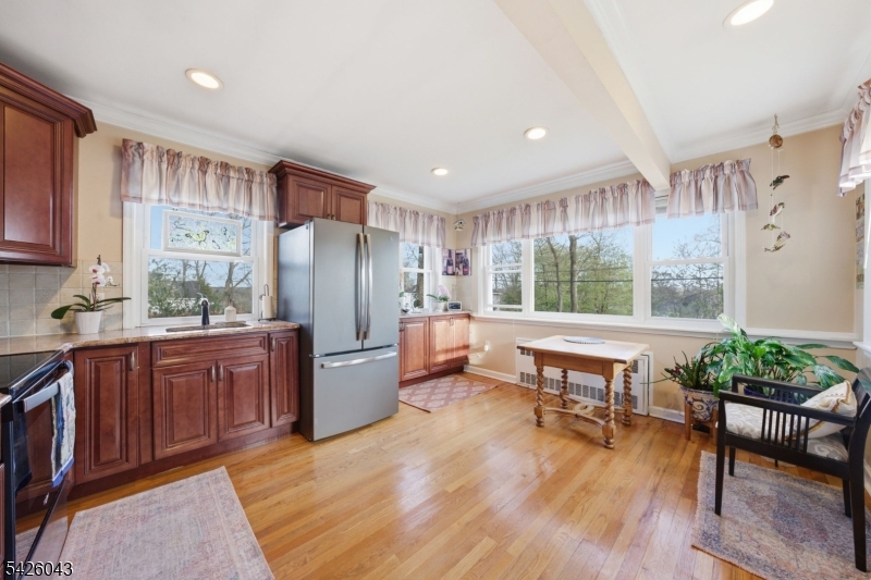 7 Valley Road Randolph, NJ 07869 - Photo 6 of 47 a kitchen with stainless steel appliances granite countertop a refrigerator a sink dishwasher a dining table and chairs with wooden floor
