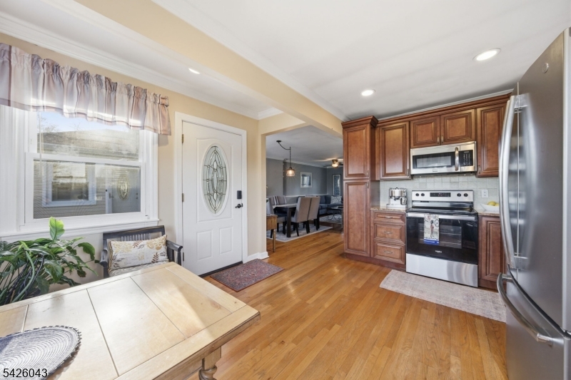 7 Valley Road Randolph, NJ 07869 - Photo 8 of 47 a large kitchen with stainless steel appliances kitchen island granite countertop a refrigerator a stove a sink a dining table and chairs with wooden floor