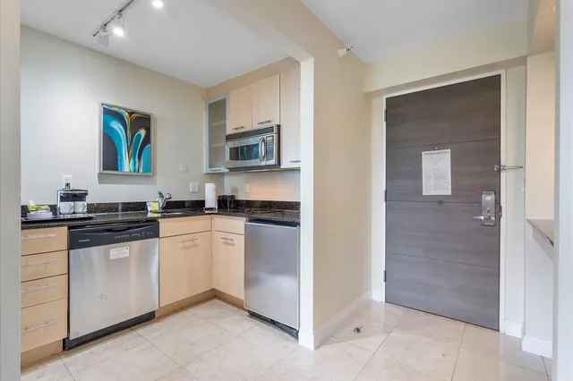 a kitchen with stainless steel appliances granite countertop a refrigerator and a stove
