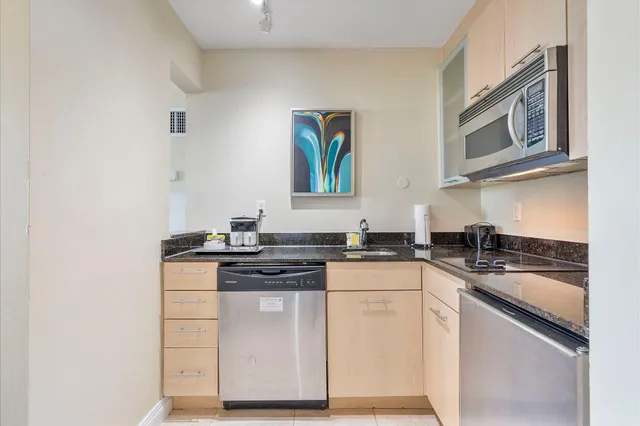 a kitchen with stainless steel appliances granite countertop a stove a sink and a microwave