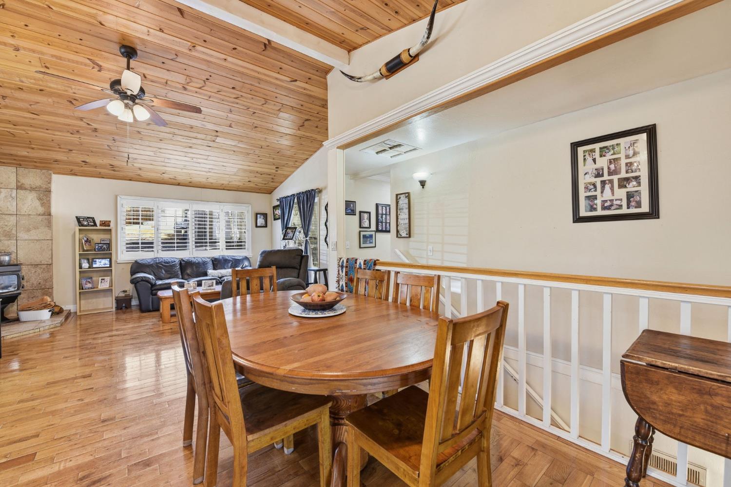 2440 Pleasant Valley Road Placerville, CA 95667 - Photo 16 of 40 dining room featuring a wood stove, a ceiling fan, a vaulted wooden ceiling, and light wood-style floors