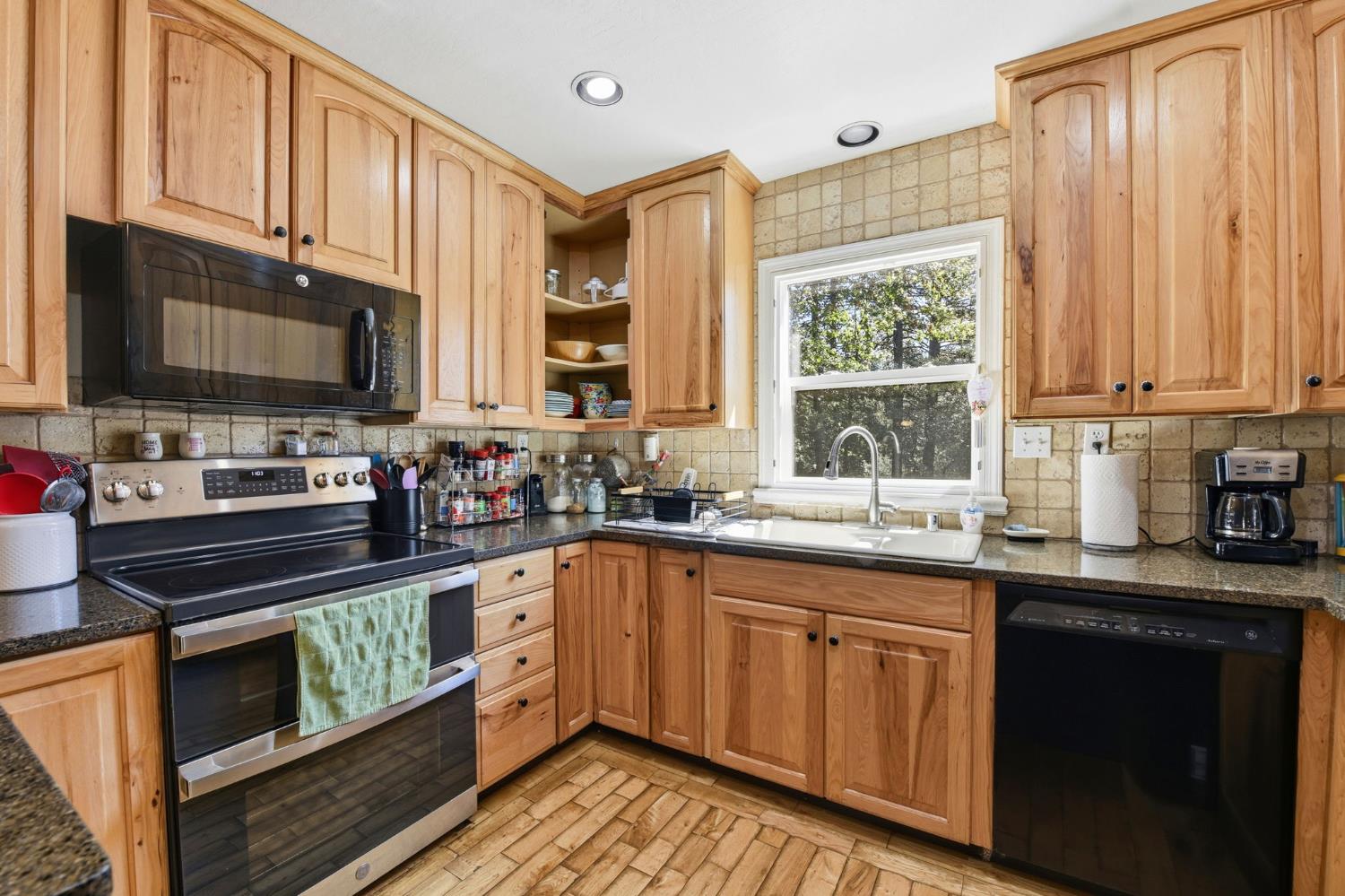 2440 Pleasant Valley Road Placerville, CA 95667 - Photo 18 of 40 kitchen with black appliances, dark stone countertops, backsplash, and open shelves