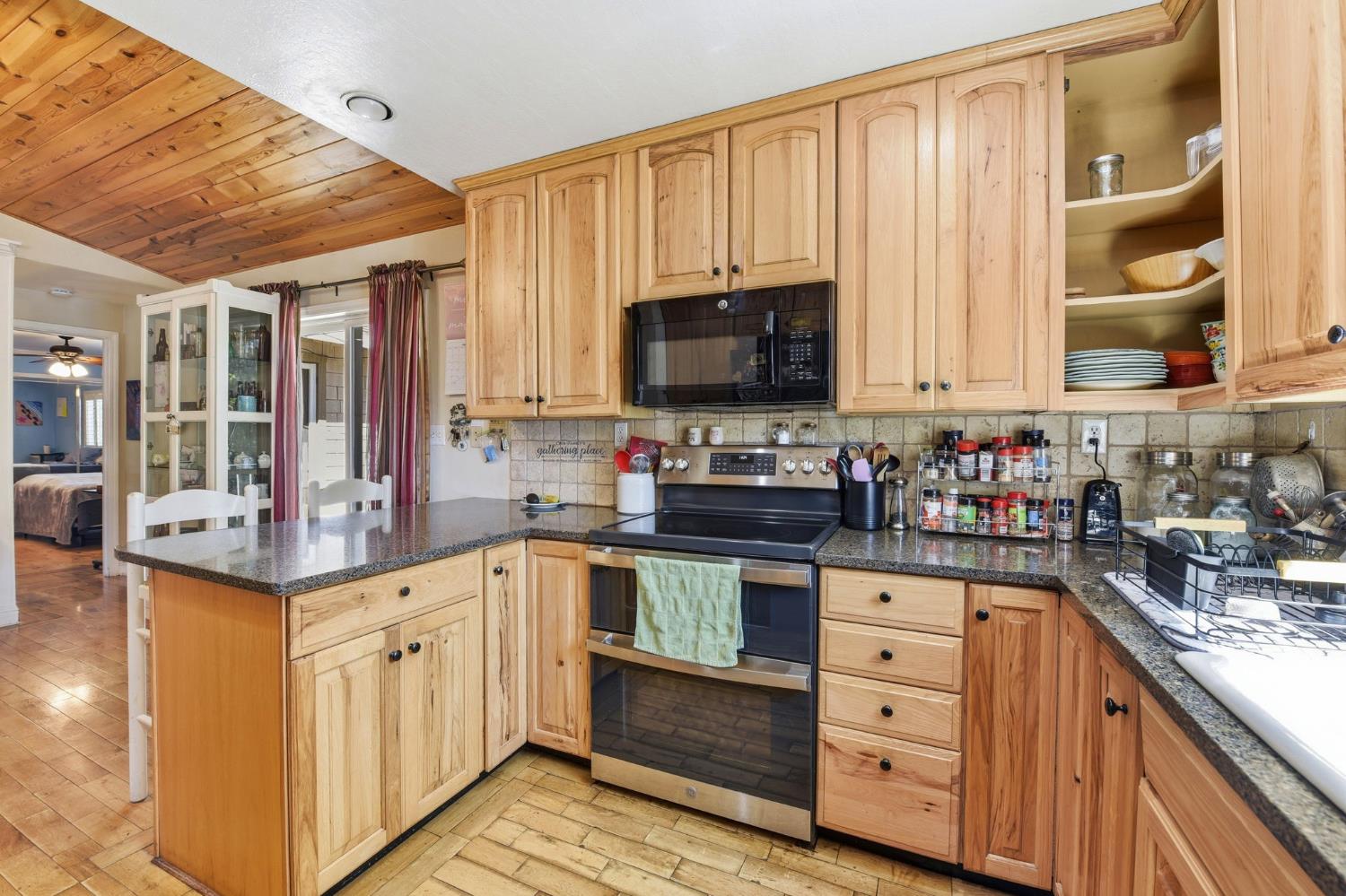 2440 Pleasant Valley Road Placerville, CA 95667 - Photo 20 of 40 kitchen with double oven range, a peninsula, light wood finish cabinets, black microwave, and a vaulted wood ceiling