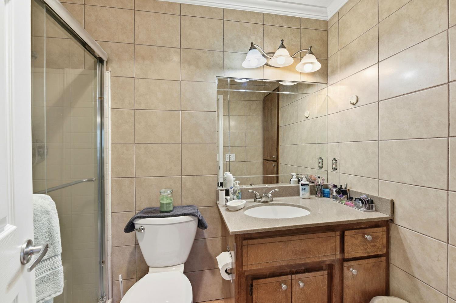 2440 Pleasant Valley Road Placerville, CA 95667 - Photo 24 of 40 bathroom with vanity, a stall shower, crown molding, and tile walls