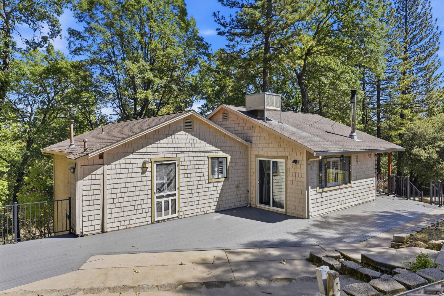 2440 Pleasant Valley Road Placerville, CA 95667 - Photo 38 of 40 view of front facade with roof with shingles, a chimney, a wooden deck, and view of scattered trees