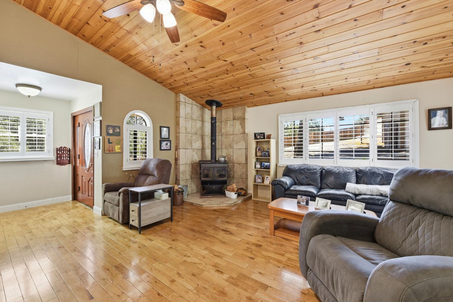 2440 Pleasant Valley Road Placerville, CA 95667 - Photo 5 of 40 living area featuring ceiling fan, a vaulted wood ceiling, light wood finished floors, and a wood stove