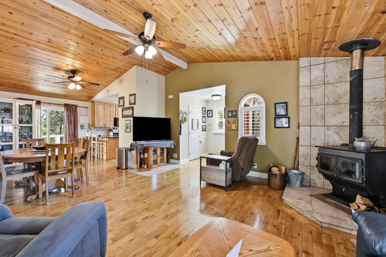 2440 Pleasant Valley Road Placerville, CA 95667 - Photo 7 of 40 living room featuring light wood-style flooring, a wood stove, ceiling fan, healthy amount of natural light, and a vaulted wooden ceiling