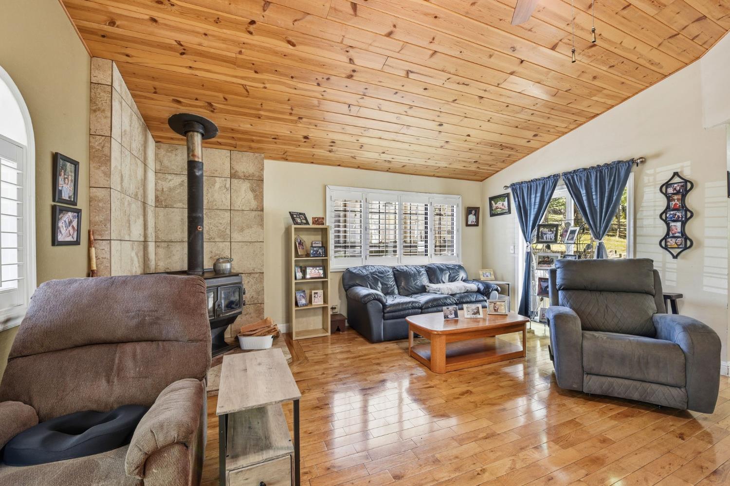 2440 Pleasant Valley Road Placerville, CA 95667 - Photo 8 of 40 living room with a vaulted wood ceiling, a wood stove, and hardwood / wood-style flooring