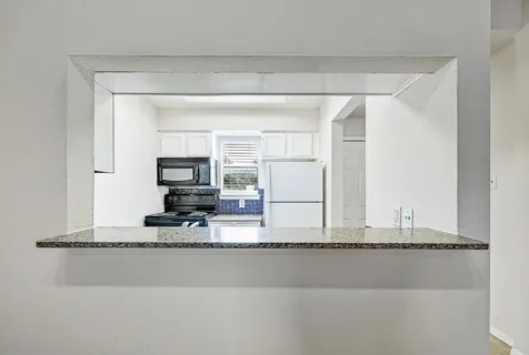 a living room with a flat screen tv and a refrigerator