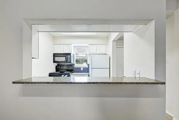 a living room with a flat screen tv and a refrigerator