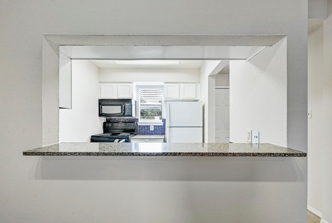 505 Bellevue Place, Unit 7 Austin, TX 78705 - Photo 7 of 24 a living room with a flat screen tv and a refrigerator