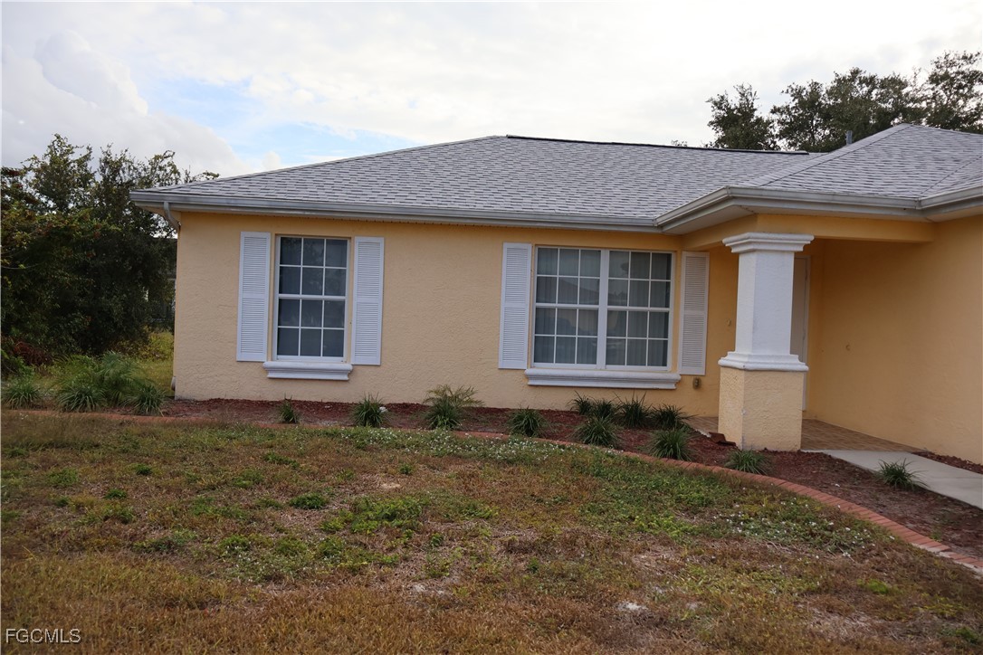 3805 22nd Street Southwest Lehigh Acres, FL 33976 - Photo 2 of 26 a front view of a house with a yard