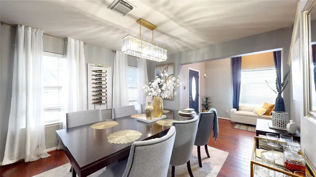 a dining room with furniture a chandelier and wooden floor