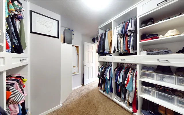a view of walk in closet with clothes and shoes