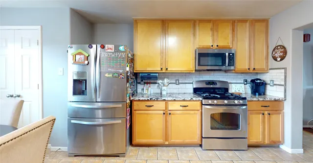 a kitchen with stainless steel appliances granite countertop a refrigerator stove and sink