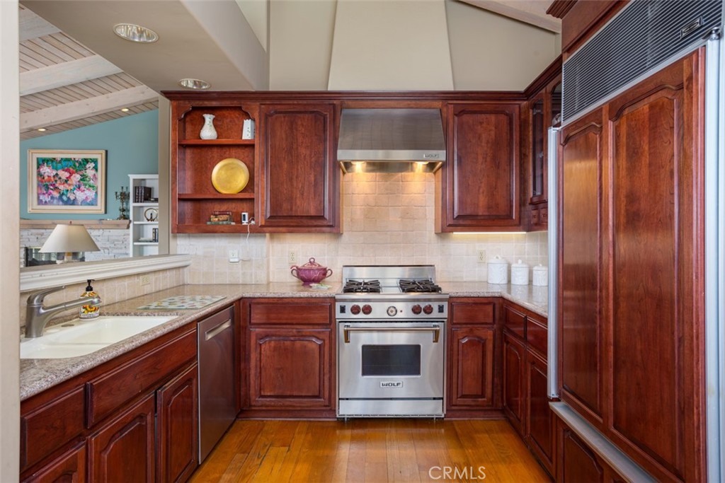 521 Emerald Bay Laguna Beach, CA 92651 - Photo 20 of 42 a kitchen with stainless steel appliances wooden cabinets and a stove top oven