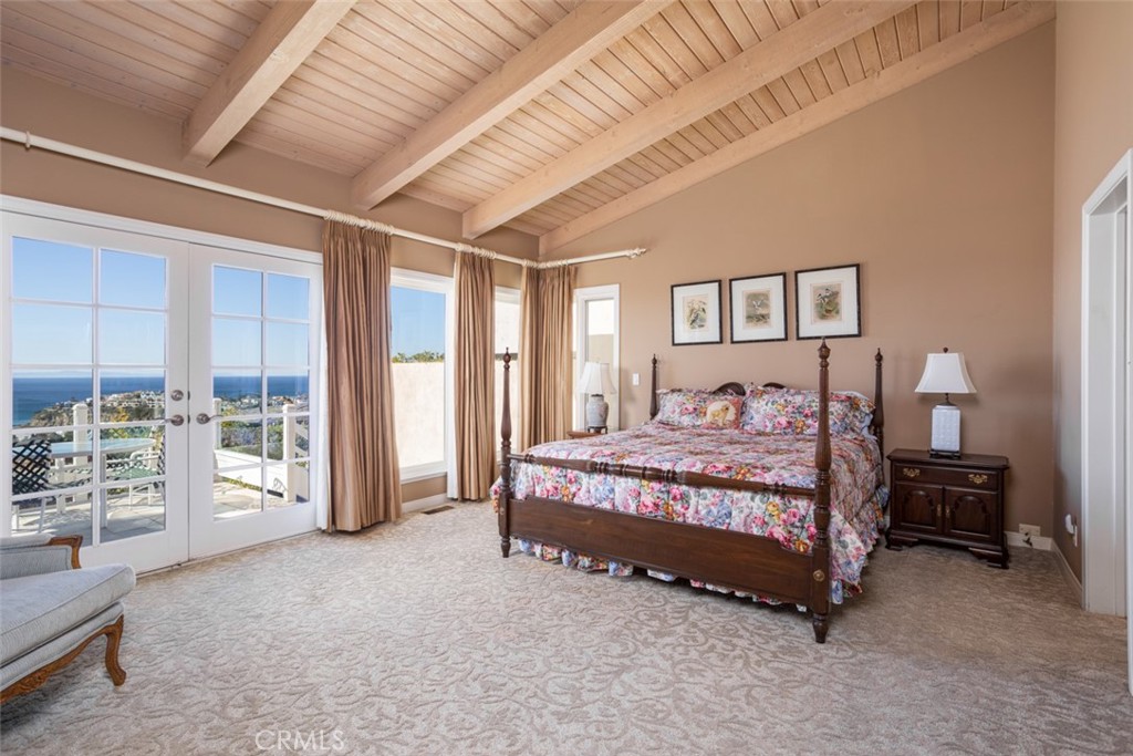 521 Emerald Bay Laguna Beach, CA 92651 - Photo 24 of 42 a spacious bedroom with a large bed and a chandelier