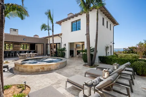 a view of a patio with table and chairs potted plants and palm tree