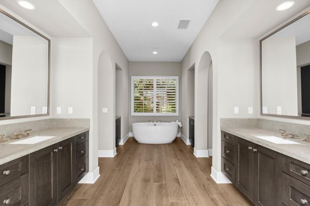 a spacious bathroom with a granite countertop tub sink and mirror