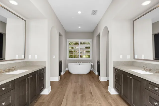 a spacious bathroom with a granite countertop tub sink and mirror
