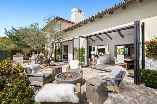 a view of a patio with couches table and chairs and potted plants