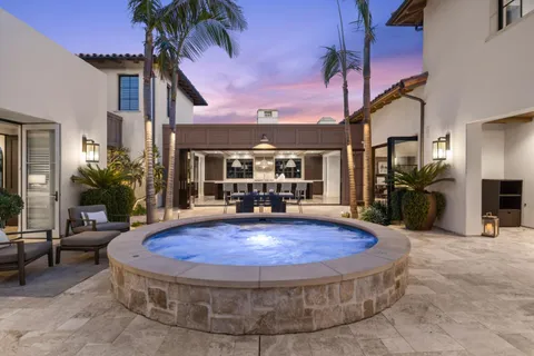 a view of a house with a swimming pool and sitting area